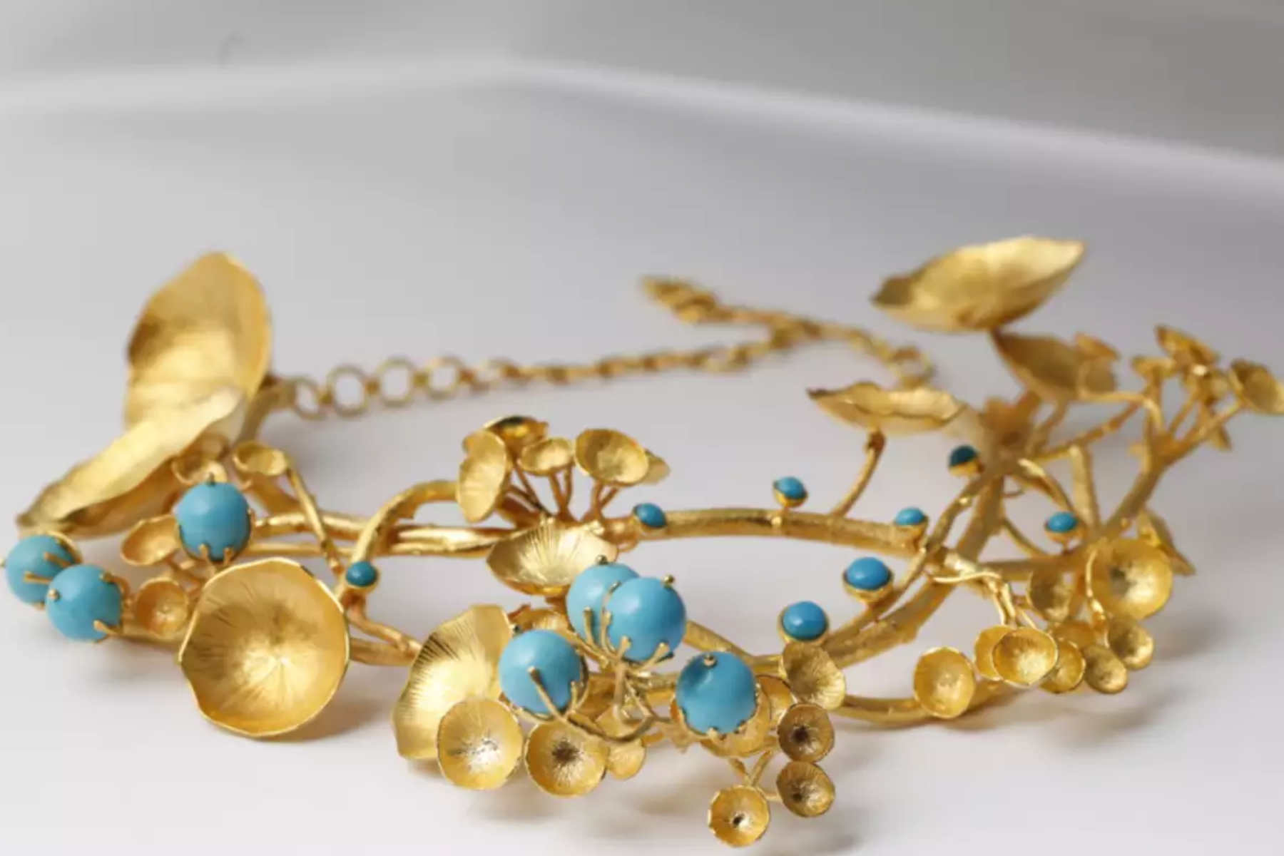 Gold floral necklace with blue stones