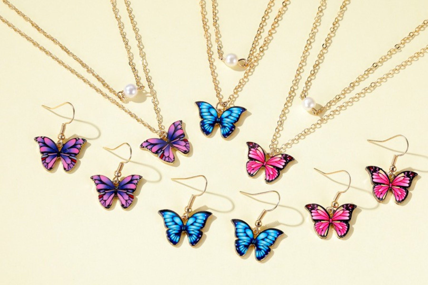 Six butterfly earrings are layered with three butterfly necklaces