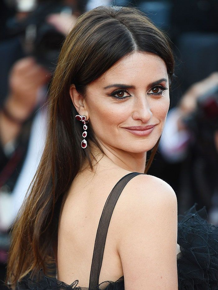 Penelope Cruz In red carpet wearing a black dress and crescent star ruby earrings