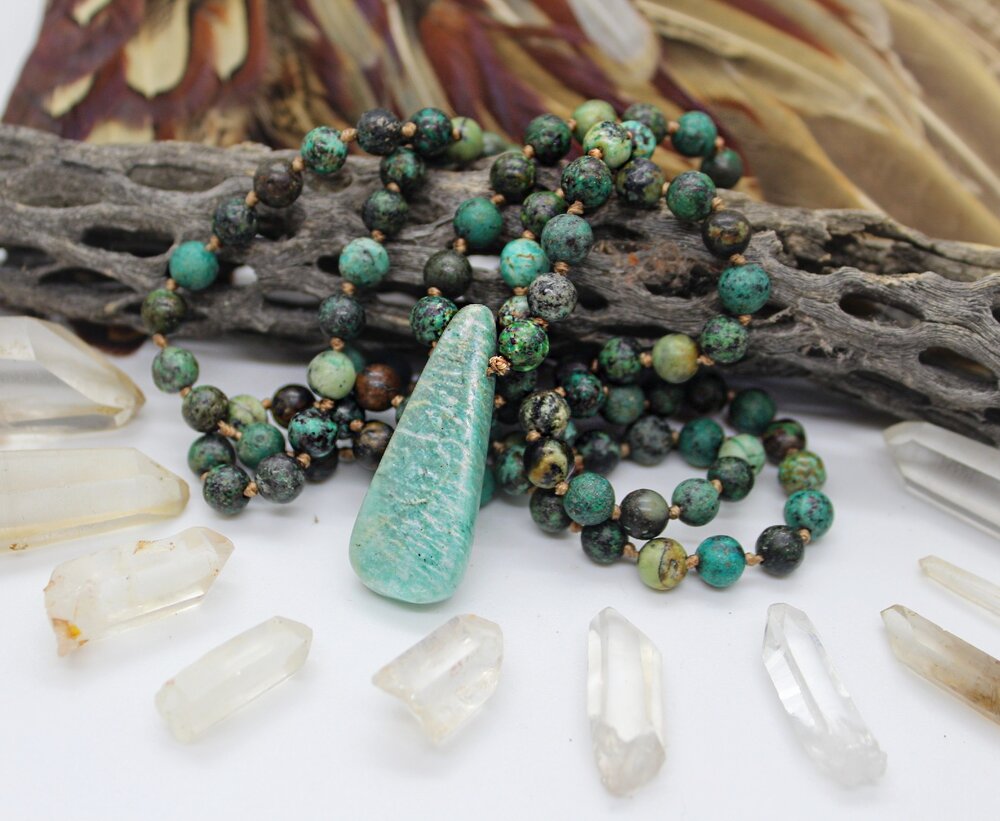 The Amazonite stone is in the center of the beaded necklace, surrounded by clear stones