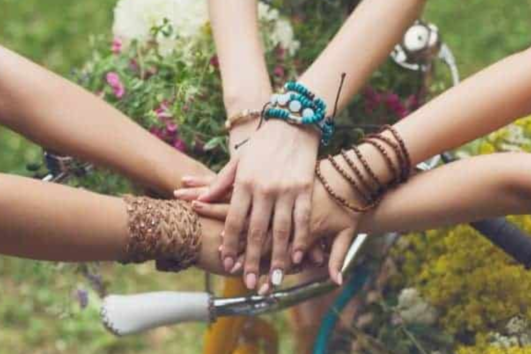 Three girls wearing friendship bracelets of various designs
