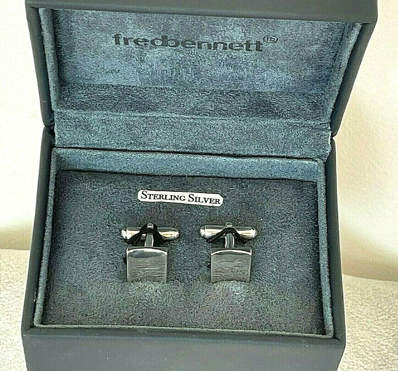 A pair of sterling silver cufflinks displayed in a jewelry case