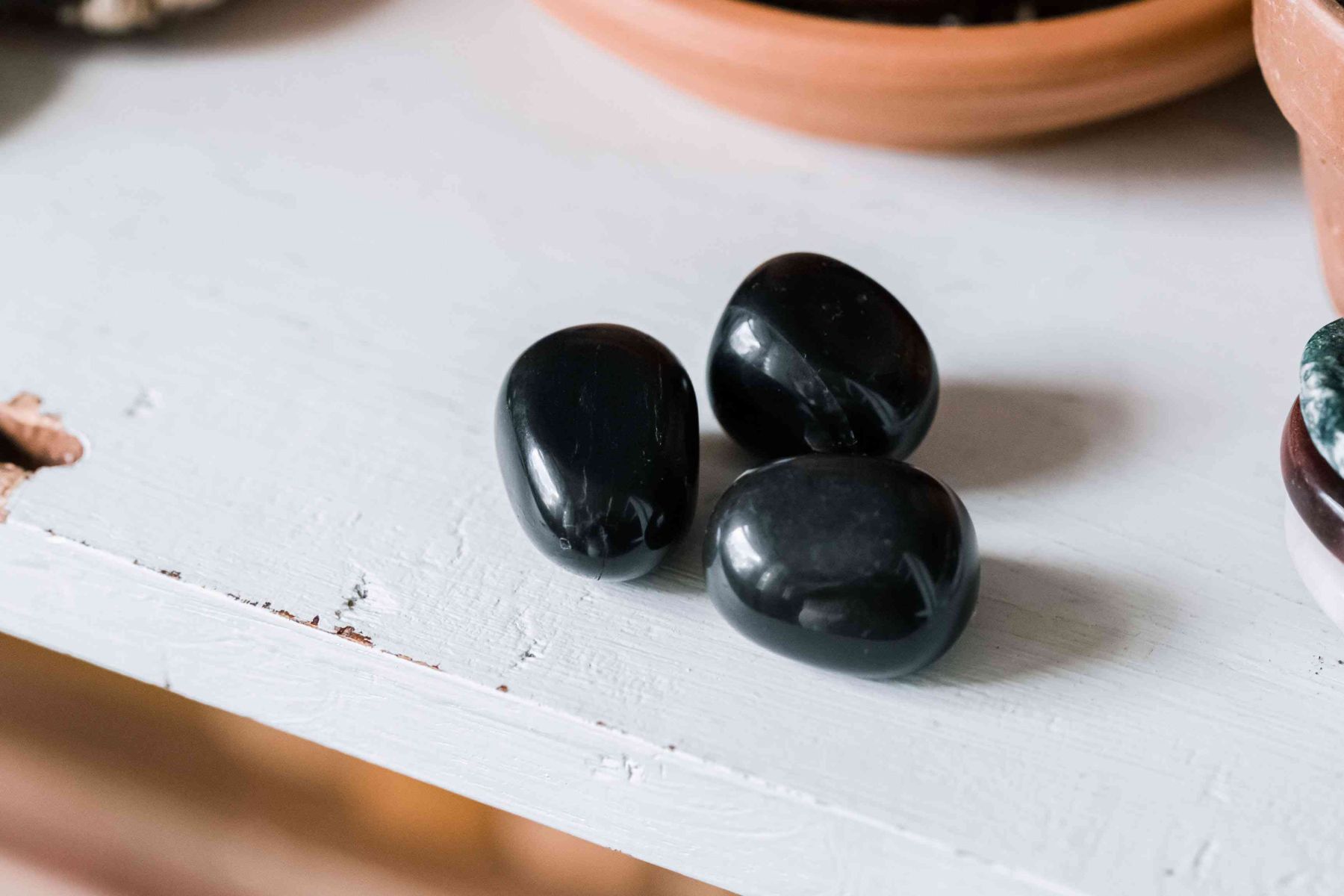 Three small pieces of black onyx on a white table