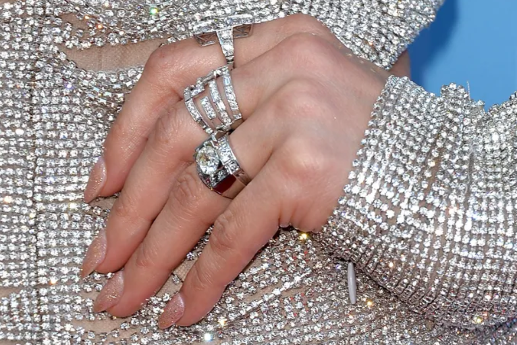 Three platinum rings are worn by a woman