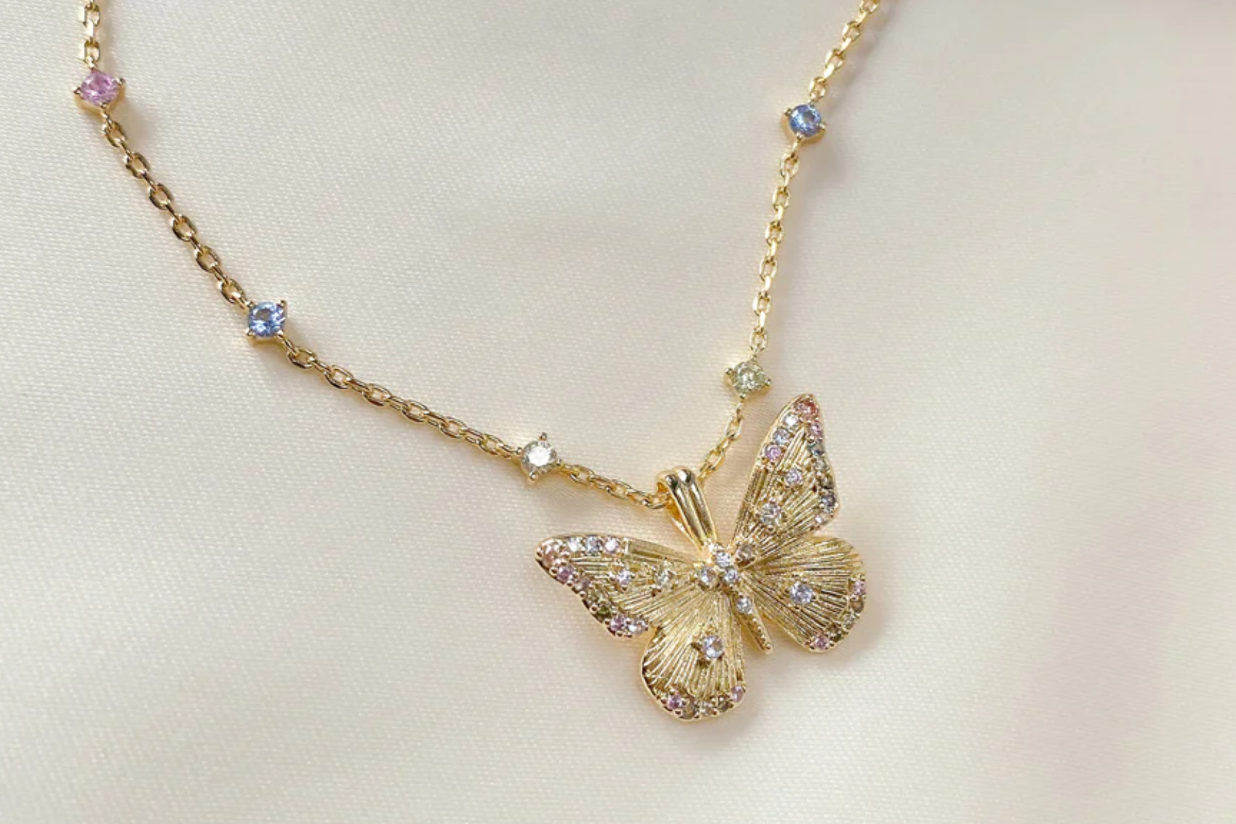 A gold butterfly necklace set with various gemstones
