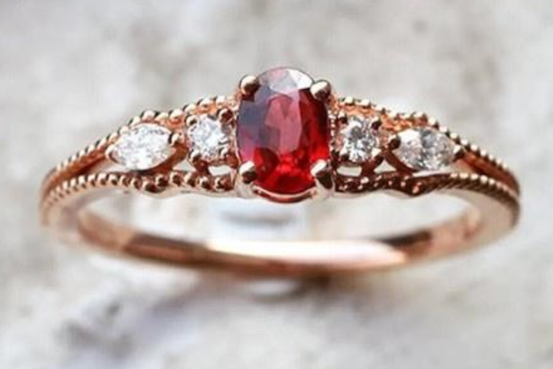 A ruby gemstone engagement ring surrounded by four diamonds