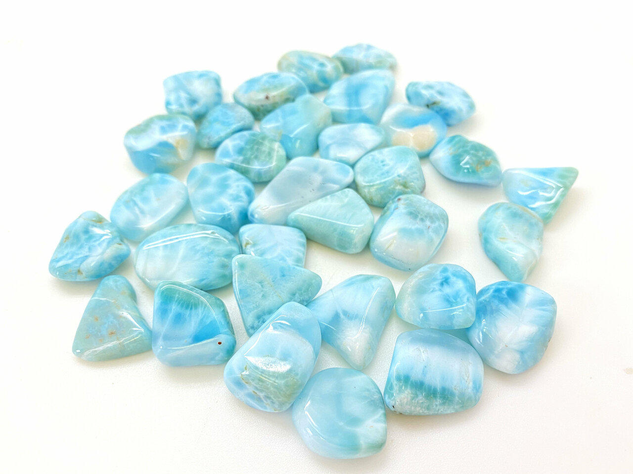 Many polished Larimar gemstones laying close to each other