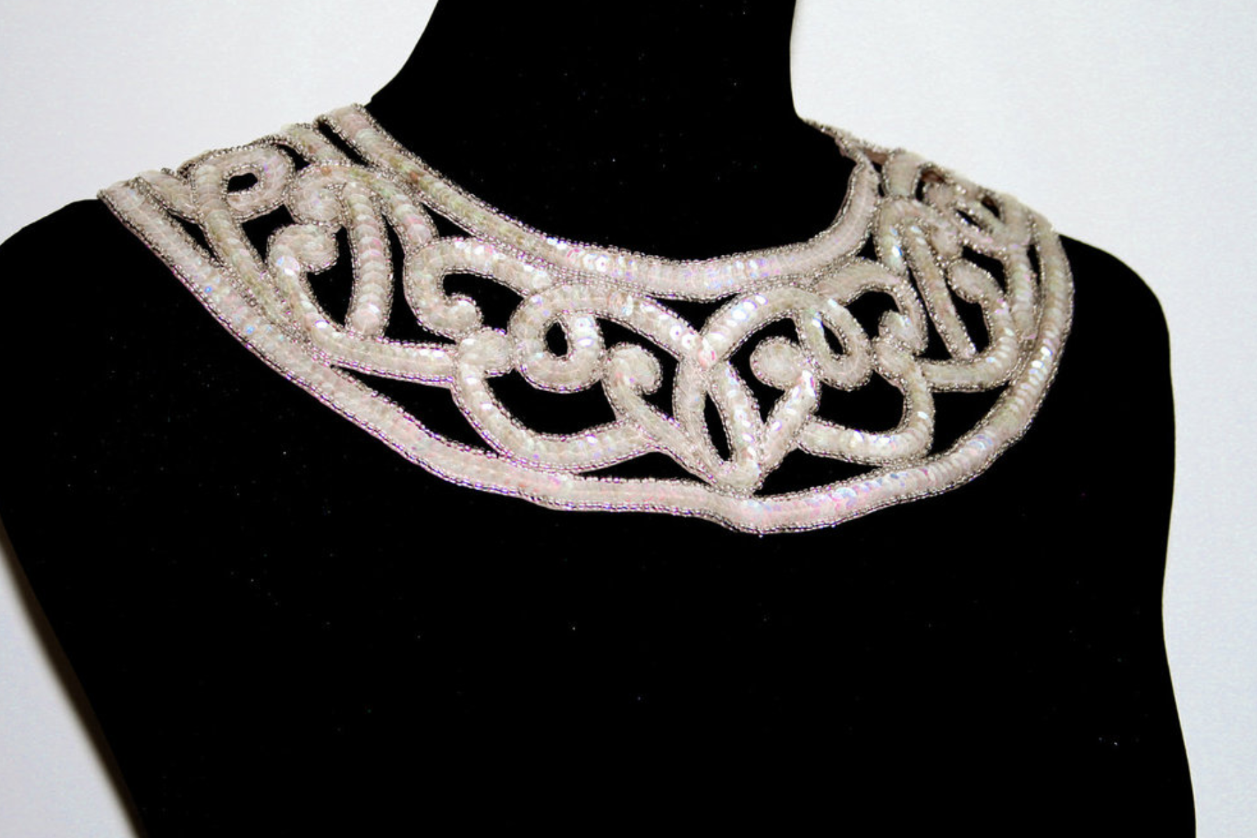 On a black body figure, an art deco statement necklace is displayed