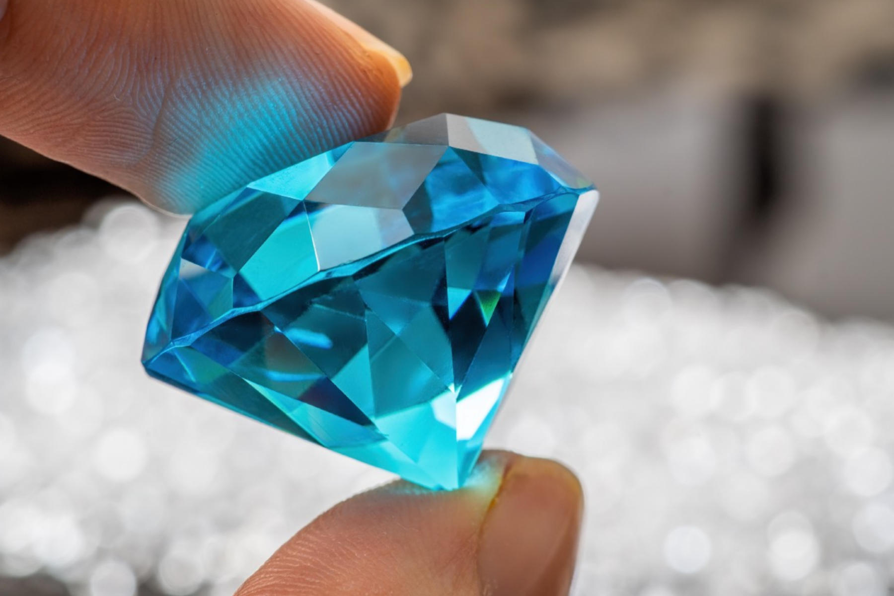 A person's hand holding blue gems