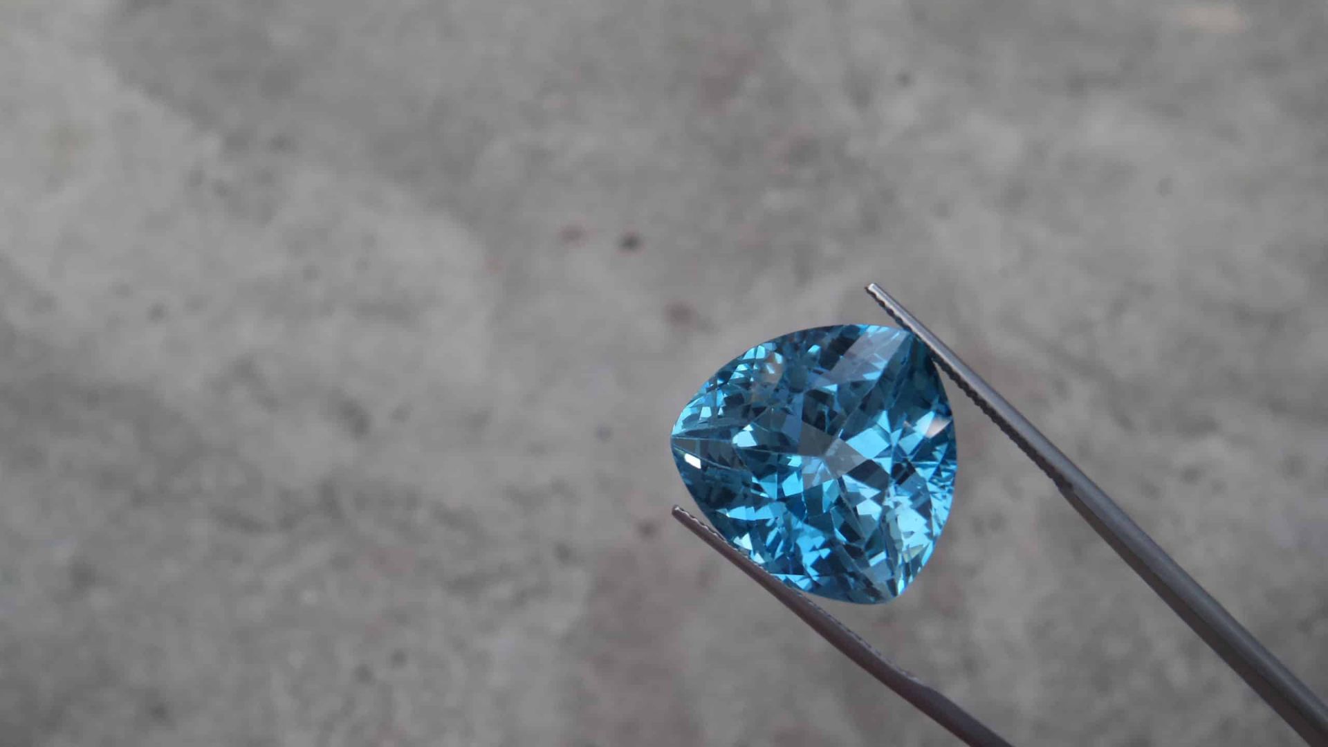Holding Blue Colored Gemstone With Metal Sticks