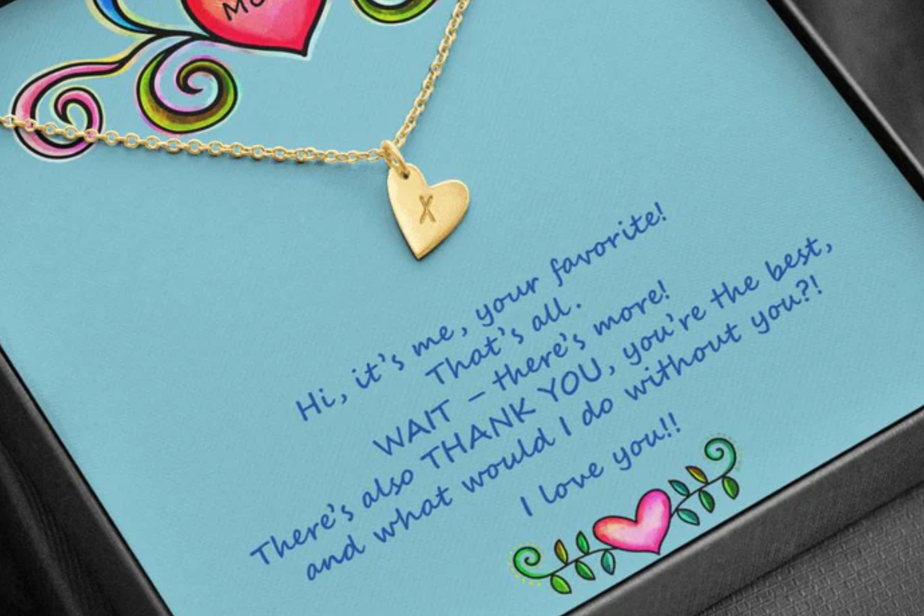 A gold charm necklace atop a mother's letter