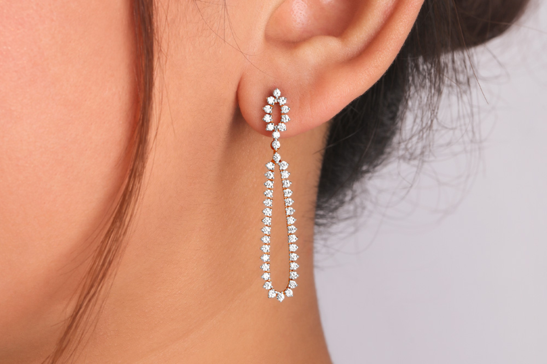 A woman's ear with a diamond drop earring