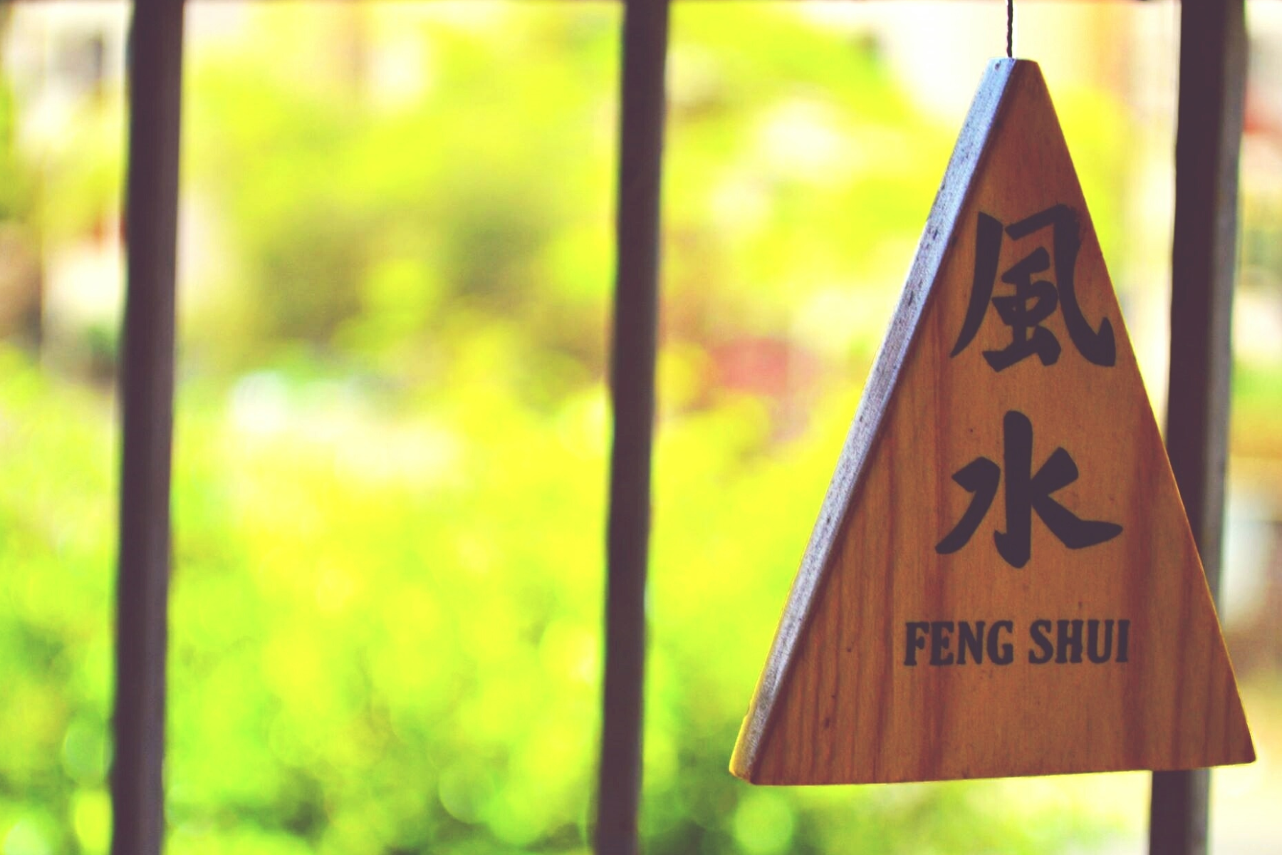 An image of a wooden triangle with the word "Feng Shui" written on it