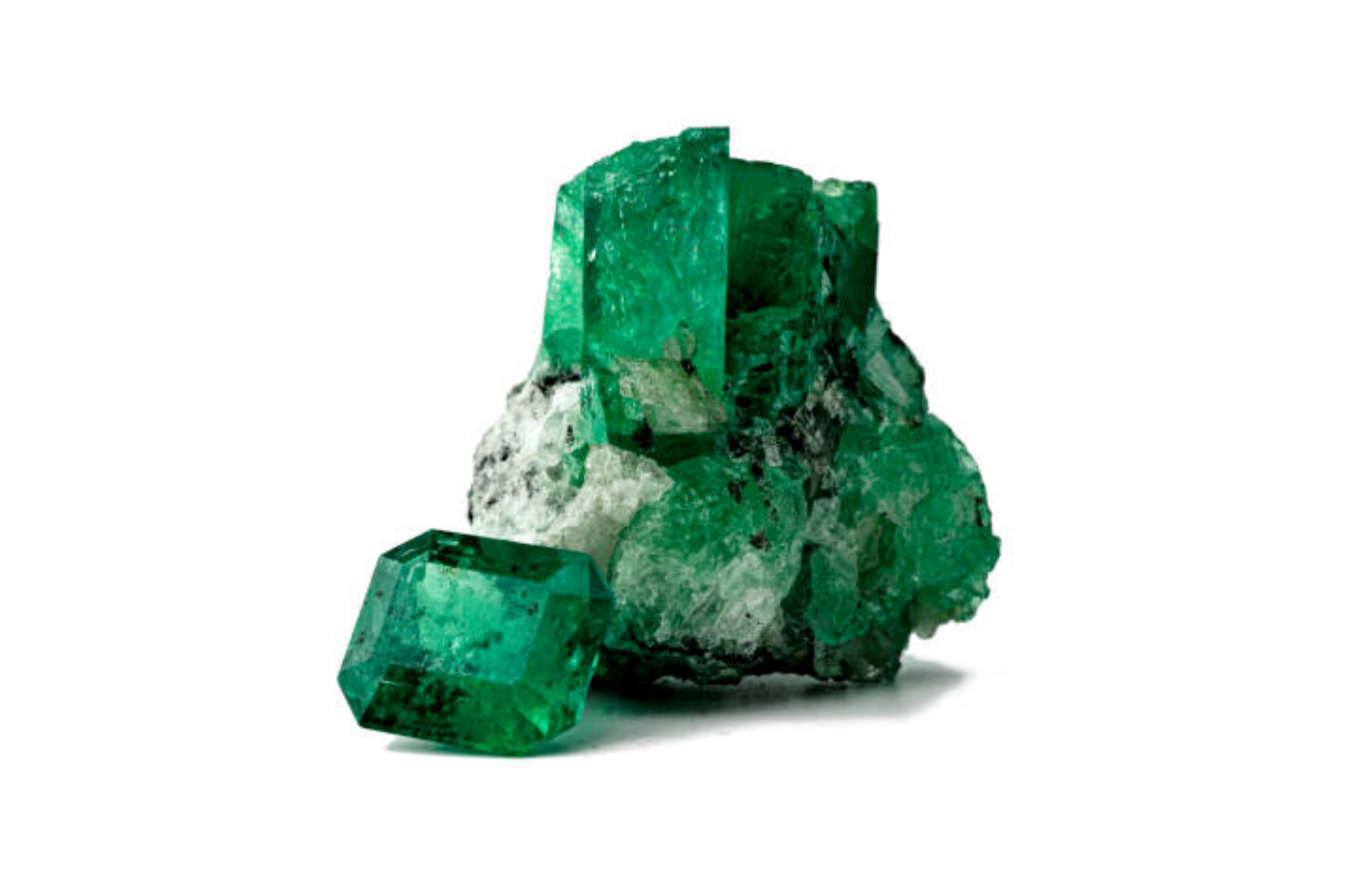 An octagonal emerald slightly inclined on a larger emerald that is still attached to its host rock