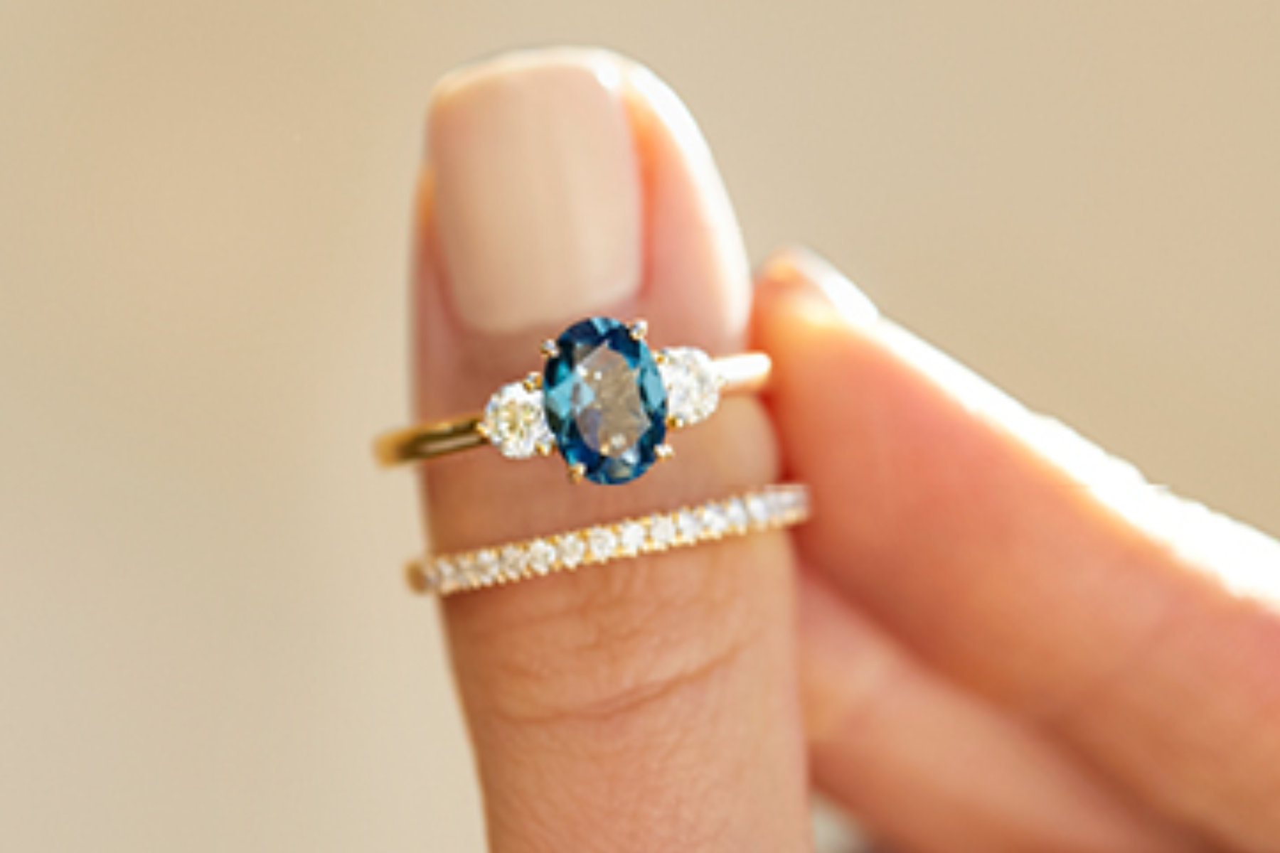 An engagement ring featuring a blue gemstone on a woman's finge
