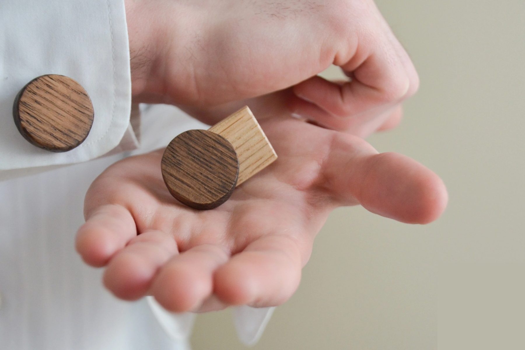 A pair of wooden cufflinks worn by a man