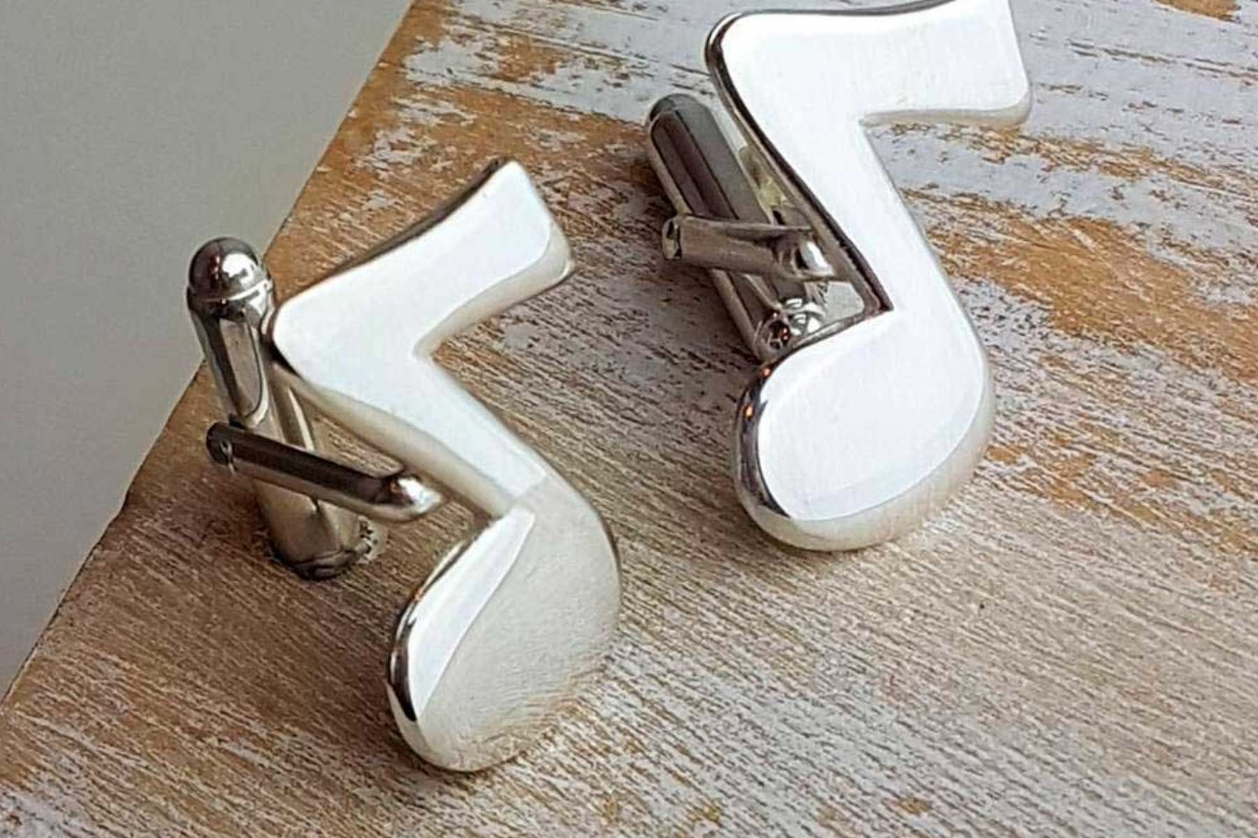 Cufflinks with music notes on a wooden table