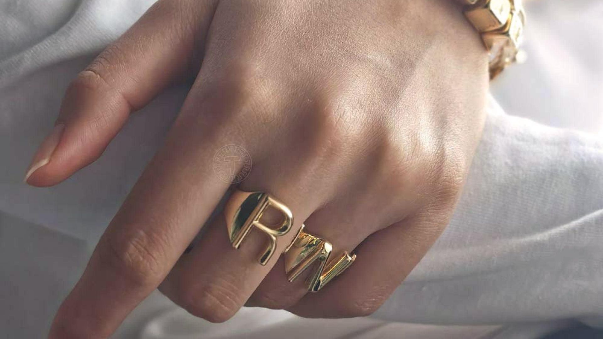 A Man Wearing Two Different Rings With Letter R And N