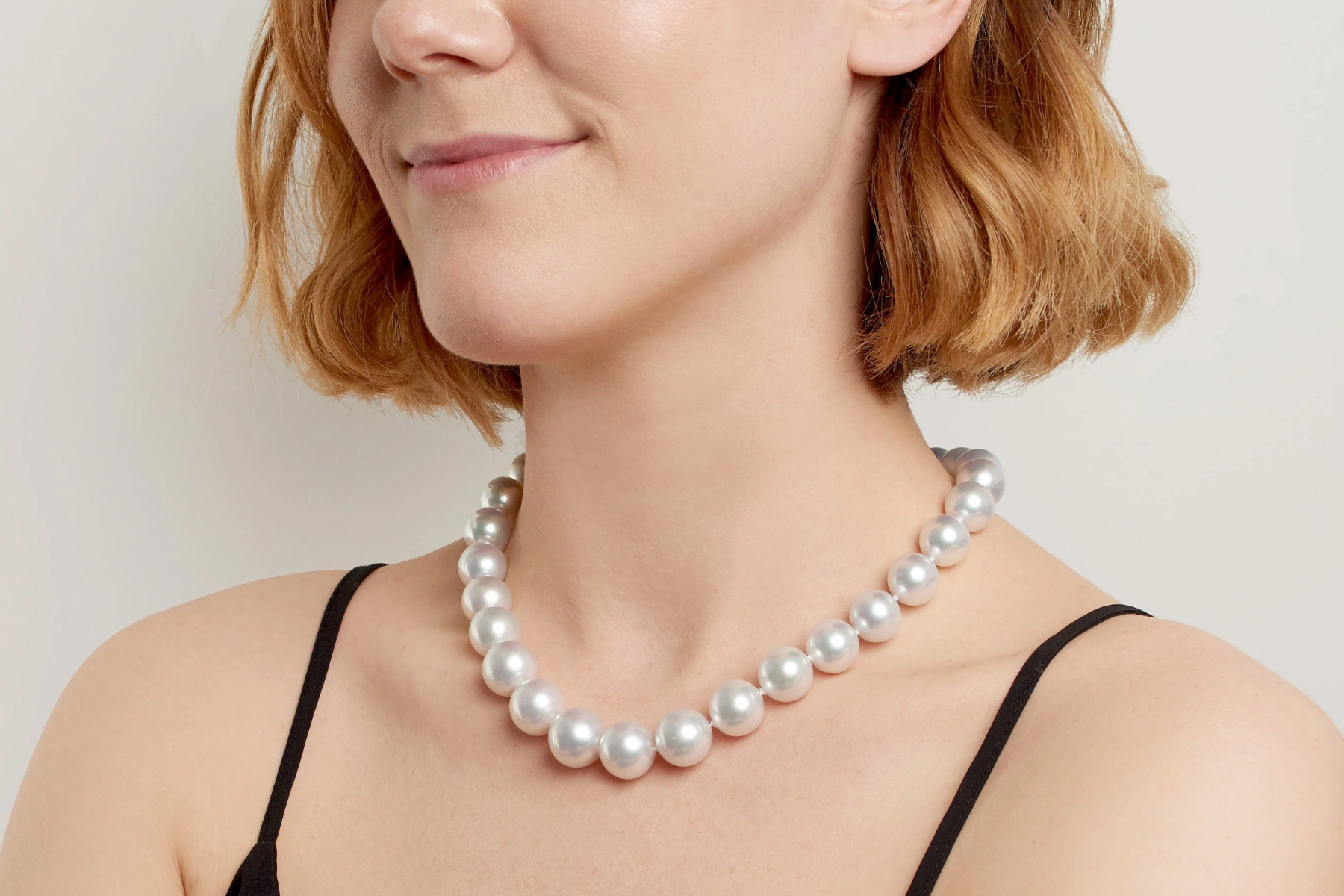 An image of an Pearl necklace being worn by a woman in a close-up shot