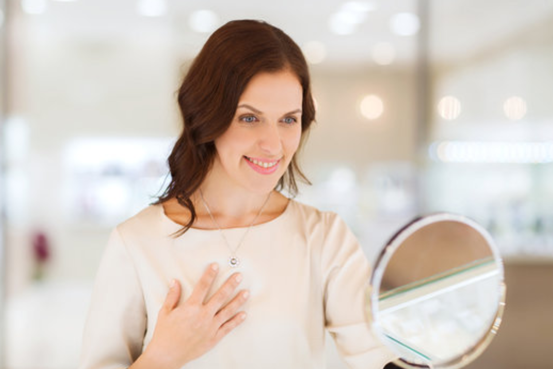 A female customer examines herself in a mirror inside a jewelry store
