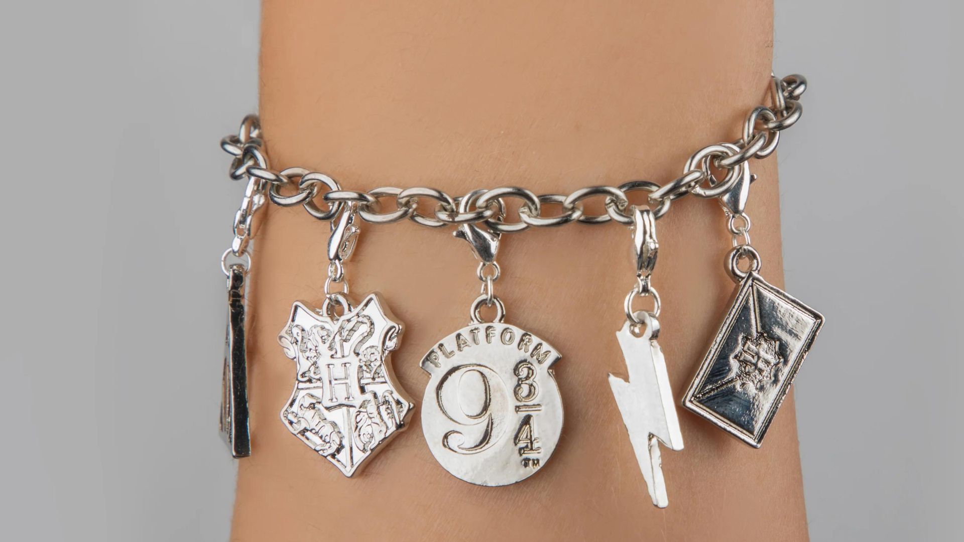 Someone Wearing Silver Bracelet With Different Signs On It