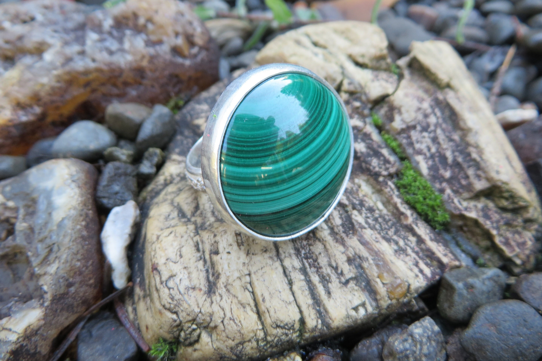A ring with a statement gemstone resting on a rock