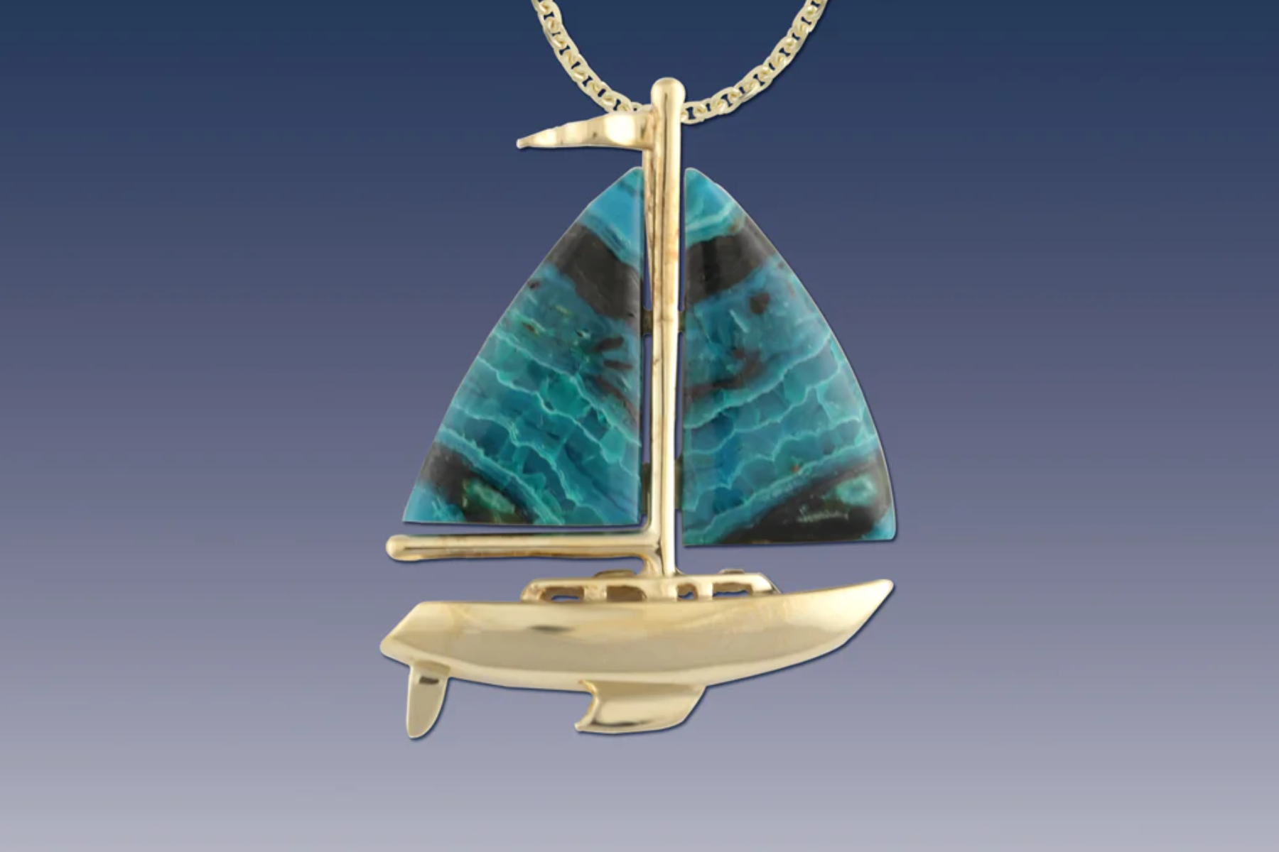 A pendant in the shape of a sailboat placed on a background with a gradient of blue colors