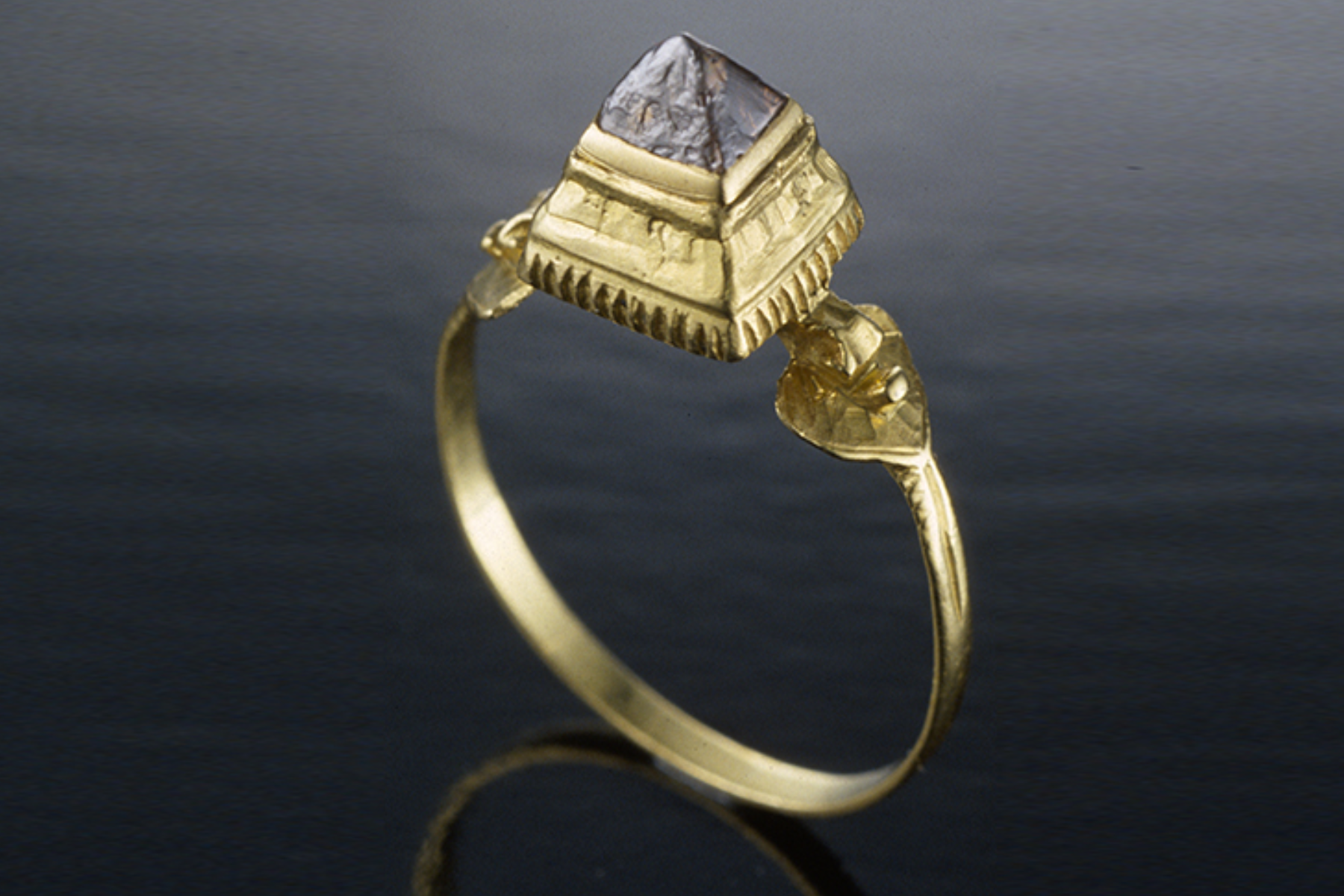 An image of a gold antique ring with a stone set at the top