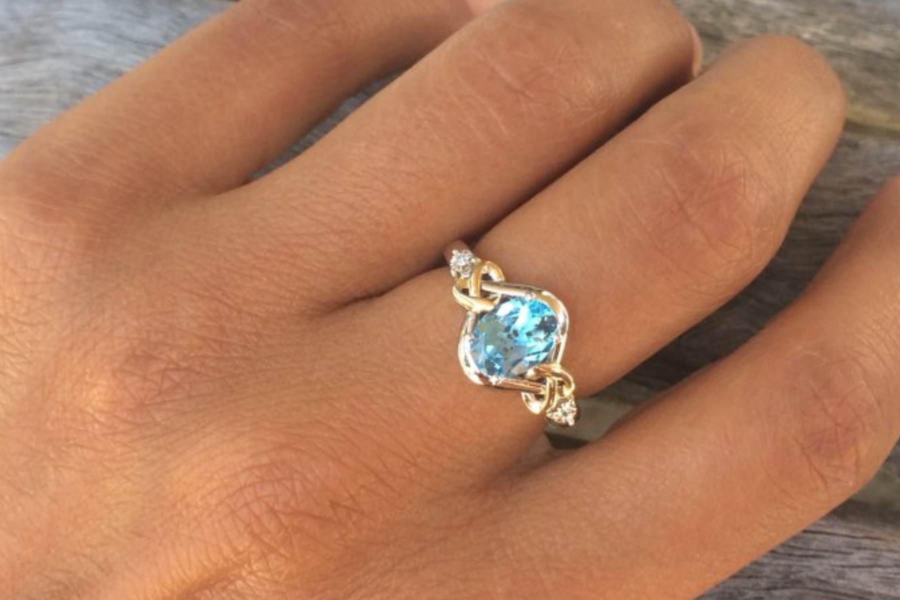 A blue topaz ring on a person's hand