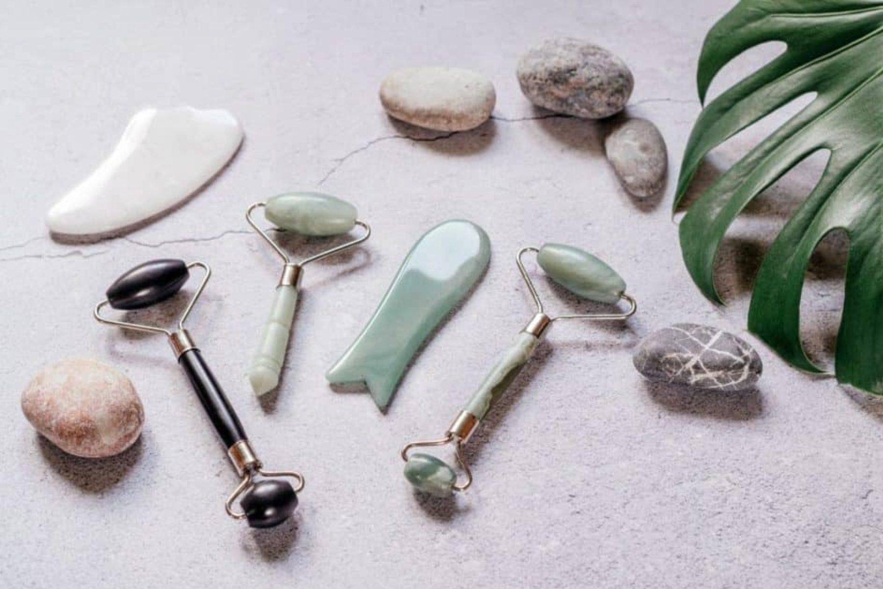 A group of three gemstone tools is placed next to various gemstones