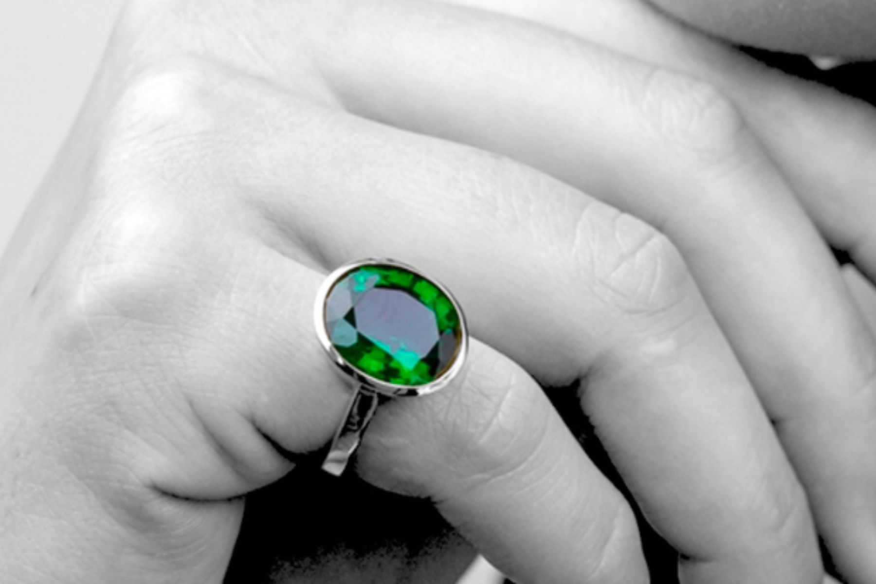 An emerald ring on the little finger