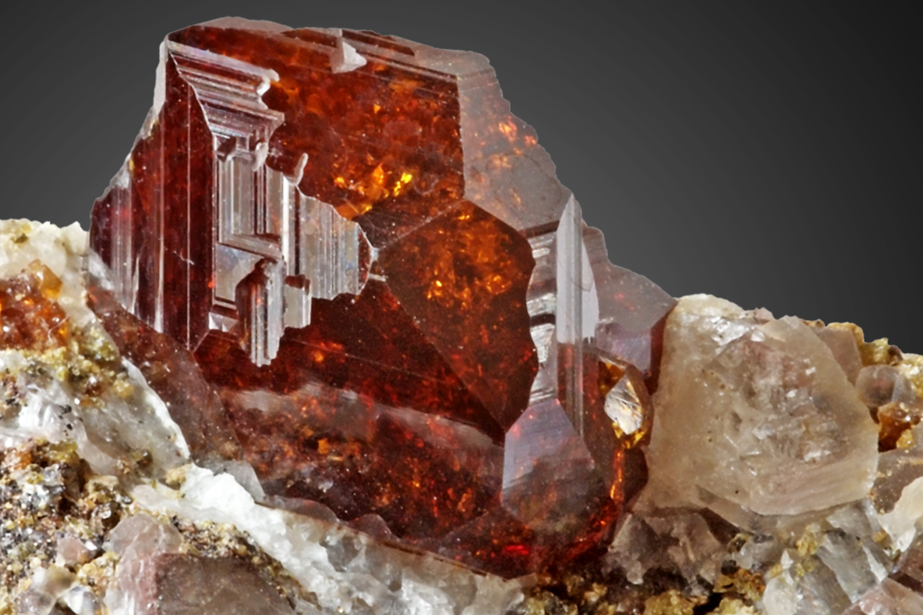 An image of a garnet stone resting on its host rock