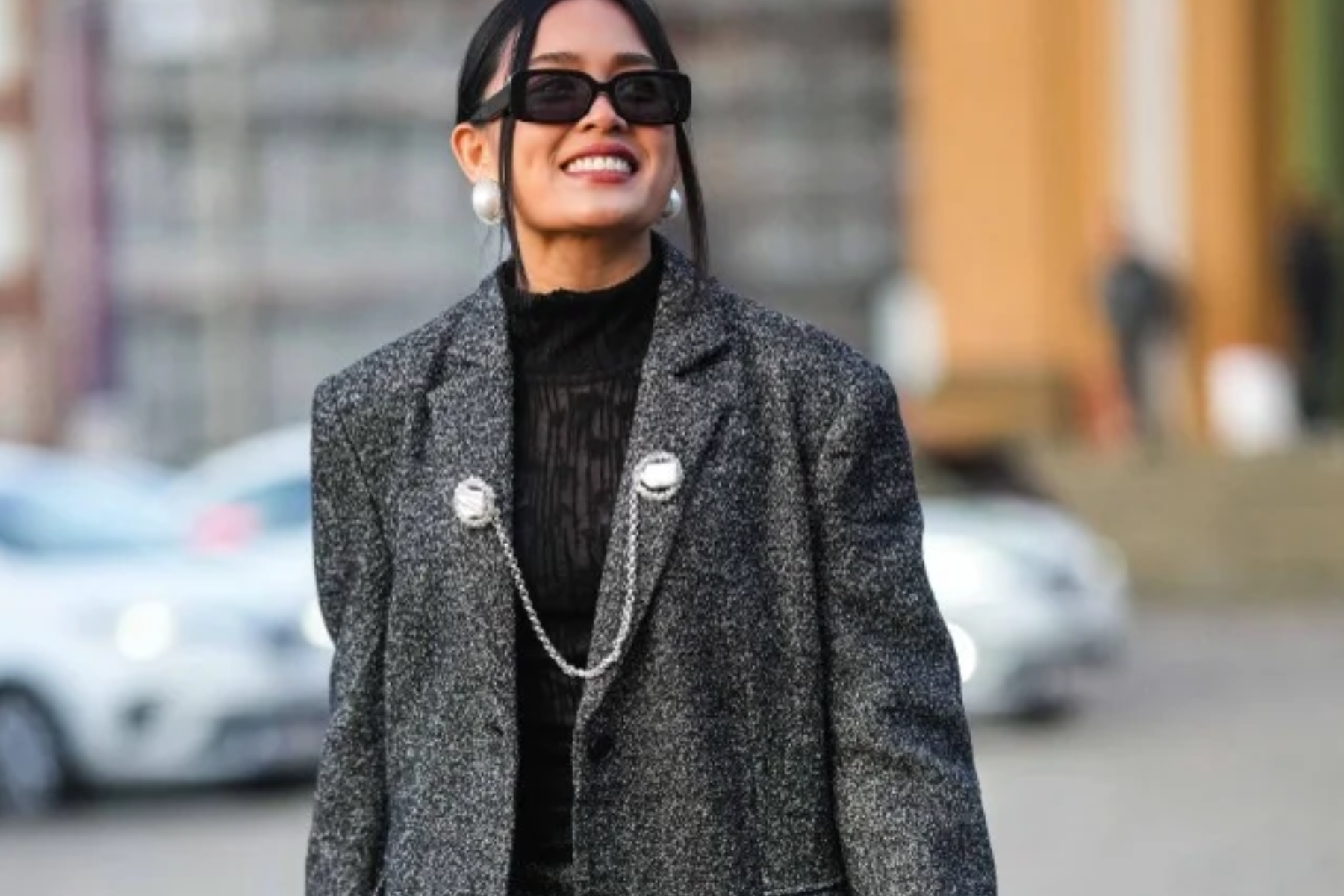 A woman walking with a chain brooch connected to her clothes