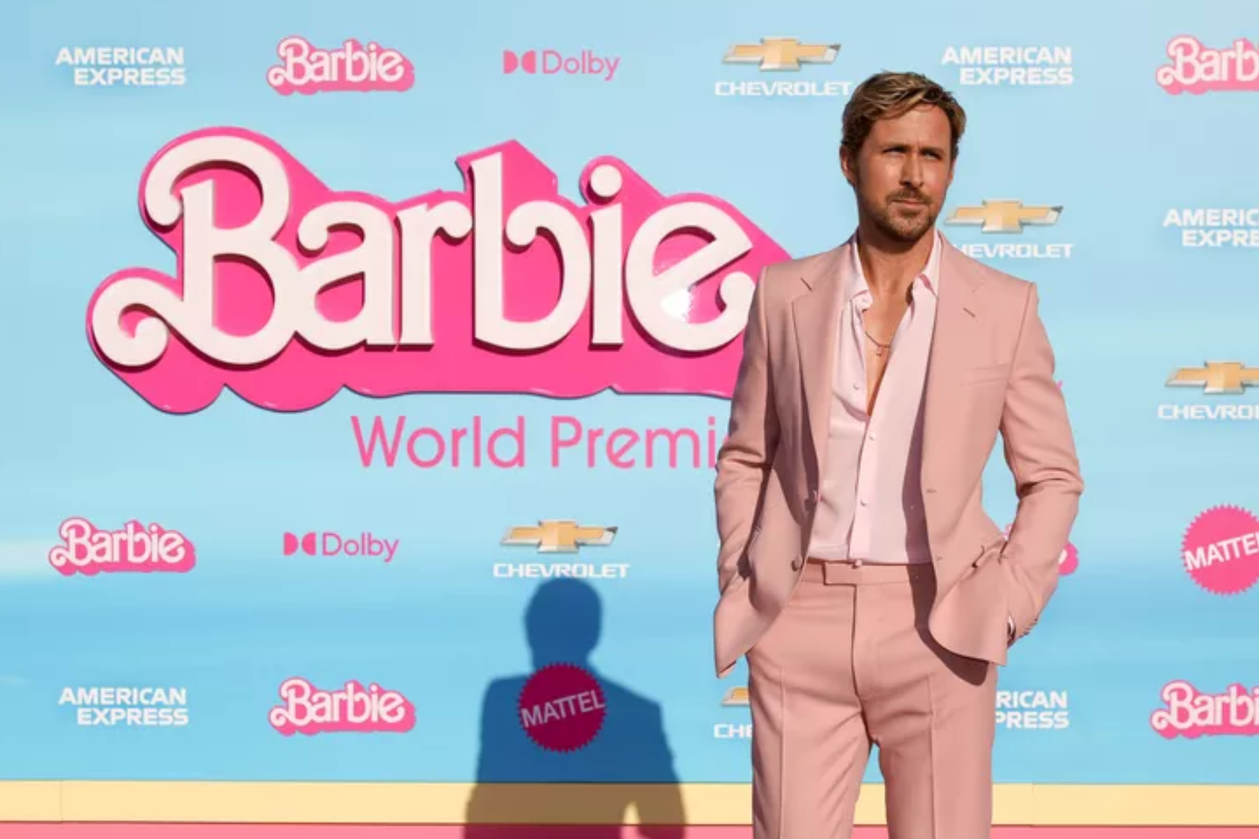 Ryan Gosling is standing in front of a Barbie World Premiere backdrop