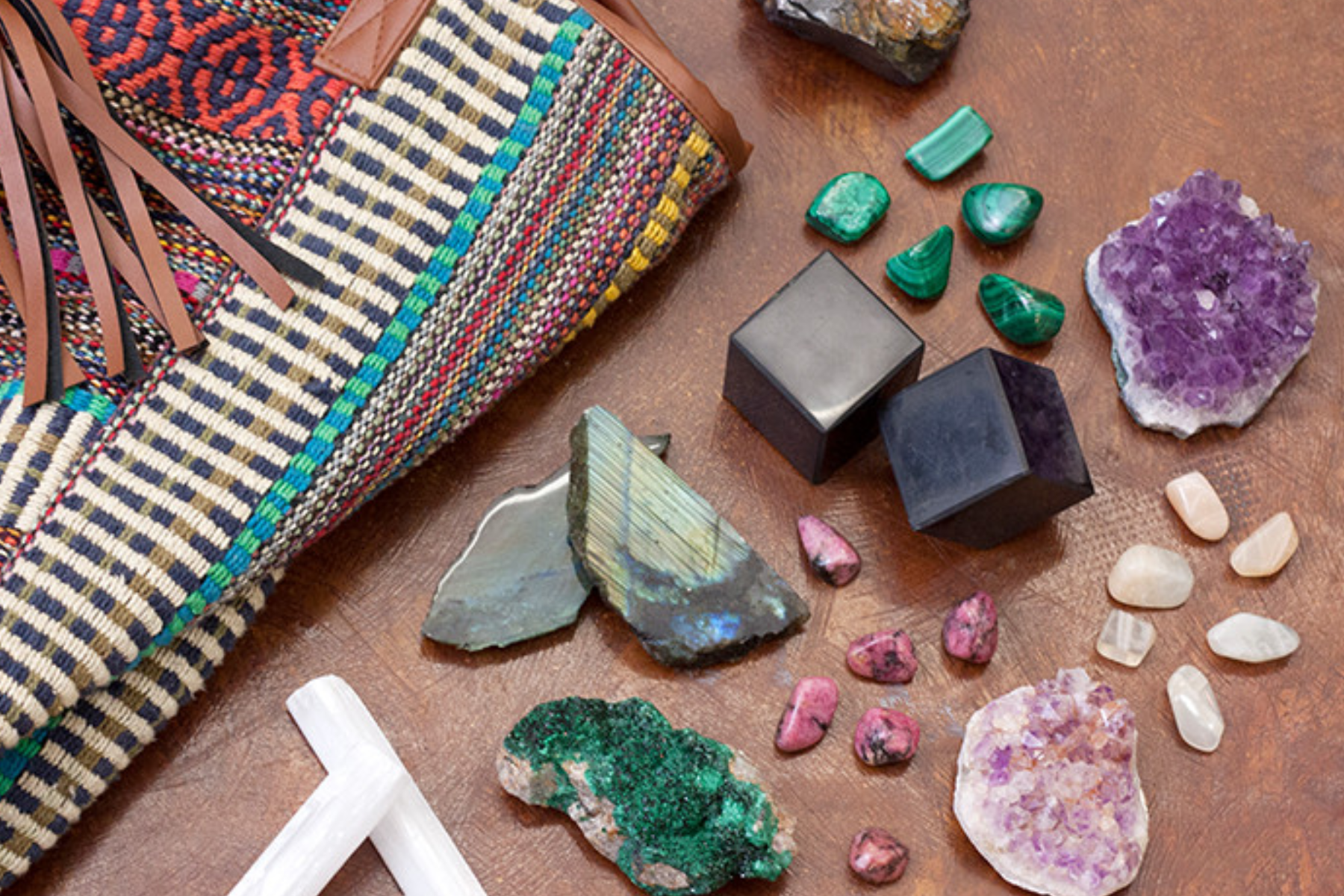 Various sorts of gemstones next to a bag