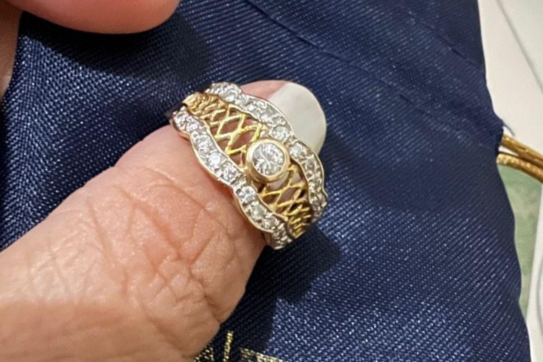 A woman's thumb models an antique ring setting
