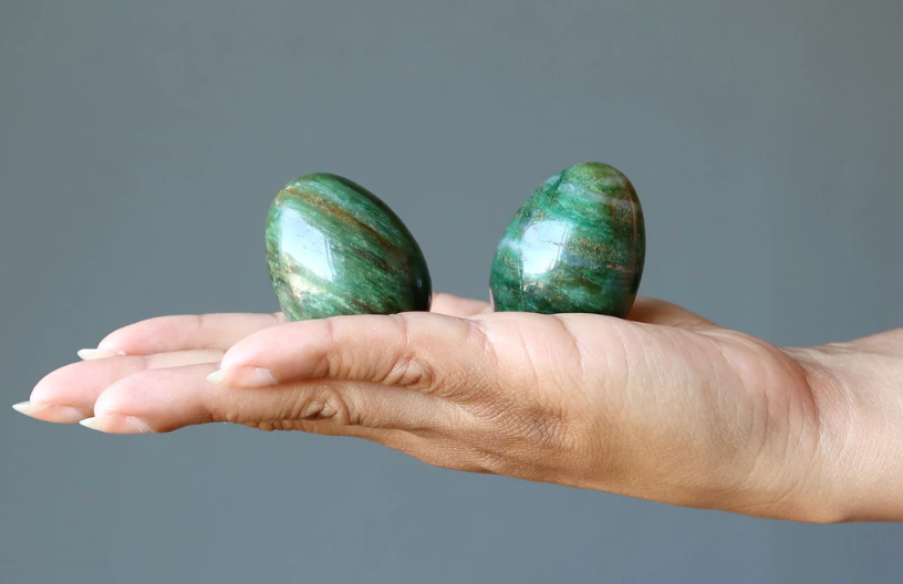 A woman's hand holds two aventurine stones