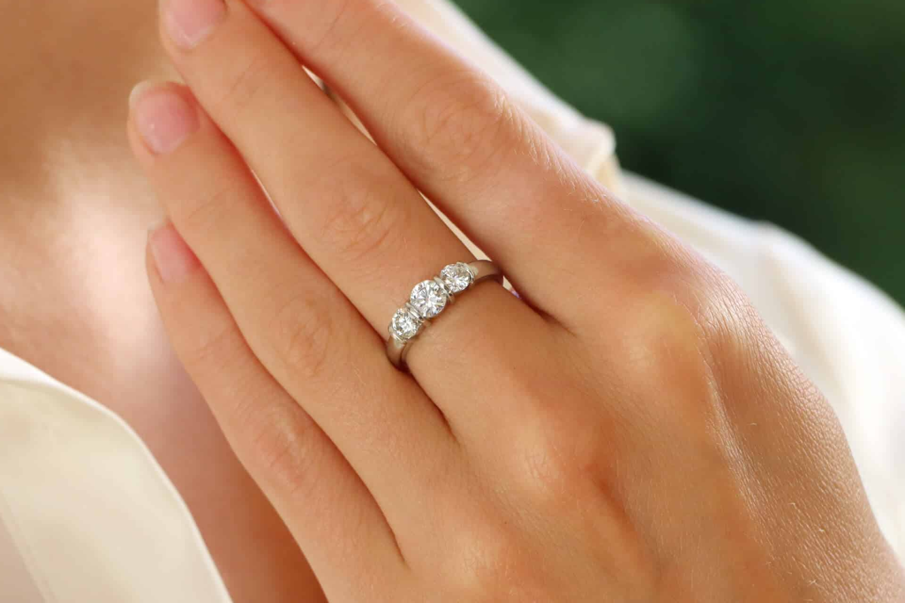 A woman has a ring with a bar setting on her middle finger