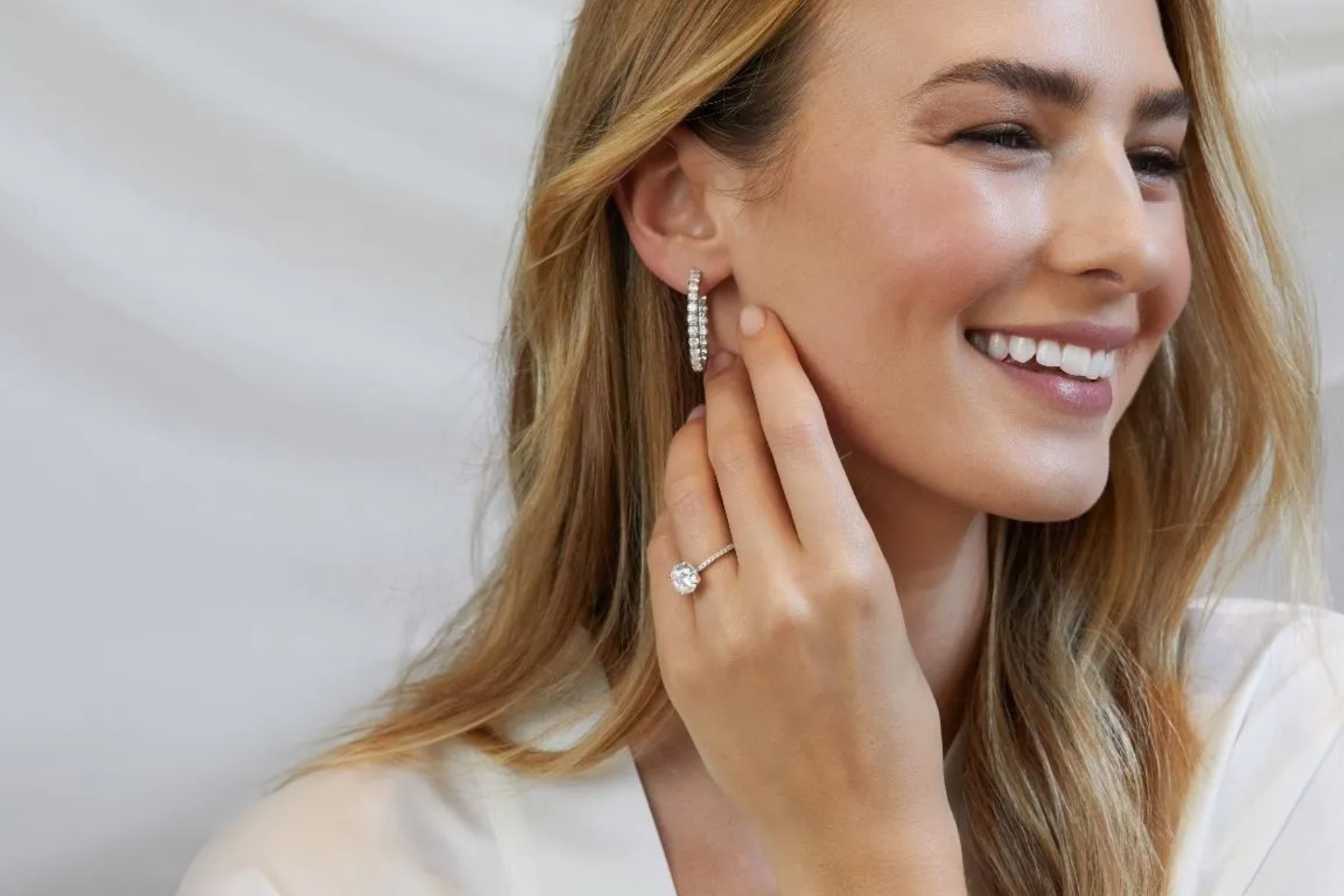A woman smiles while wearing a simple wedding band with a large diamond stone
