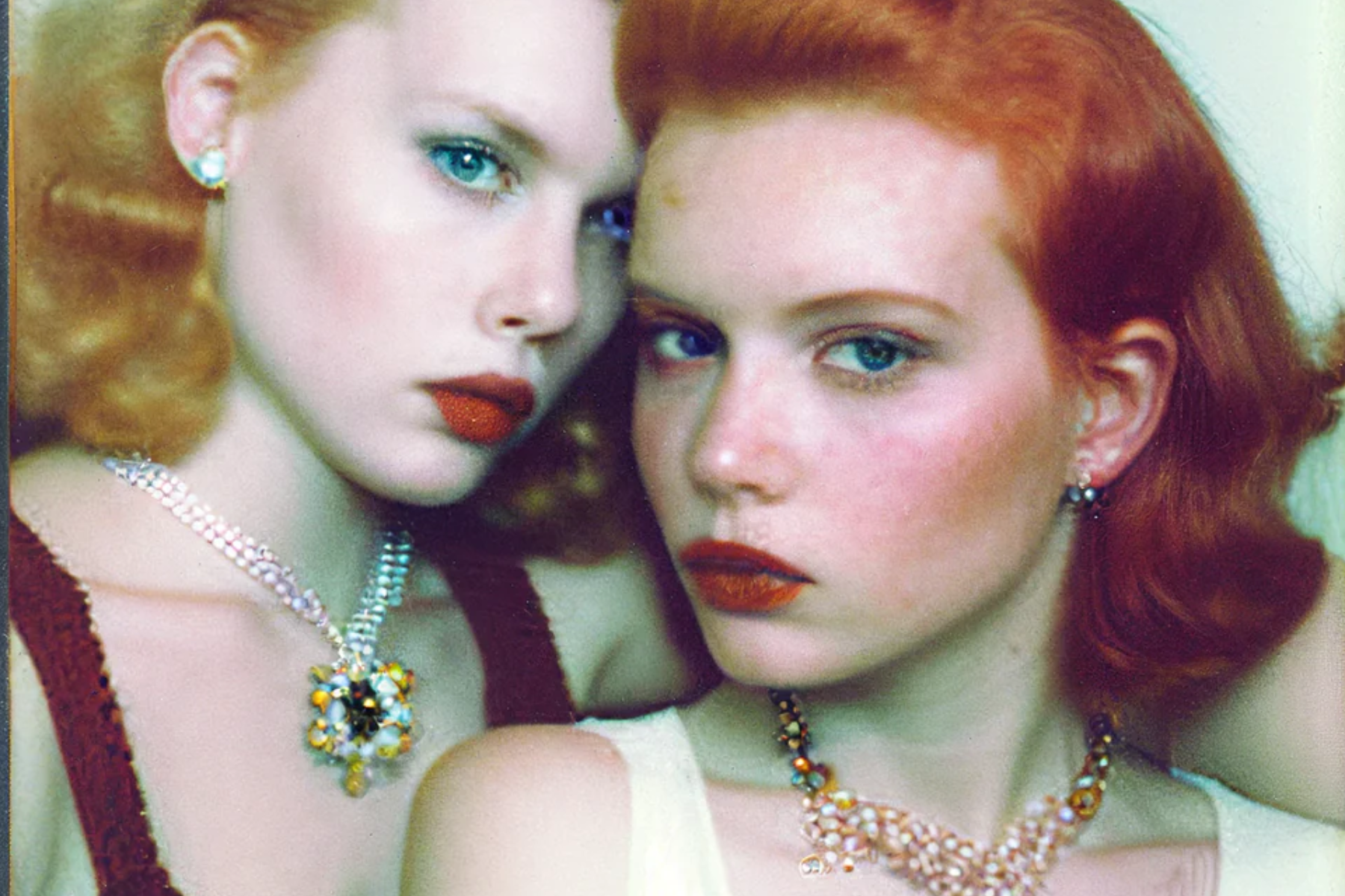 Two women are dressed in vintage necklaces and jewelry