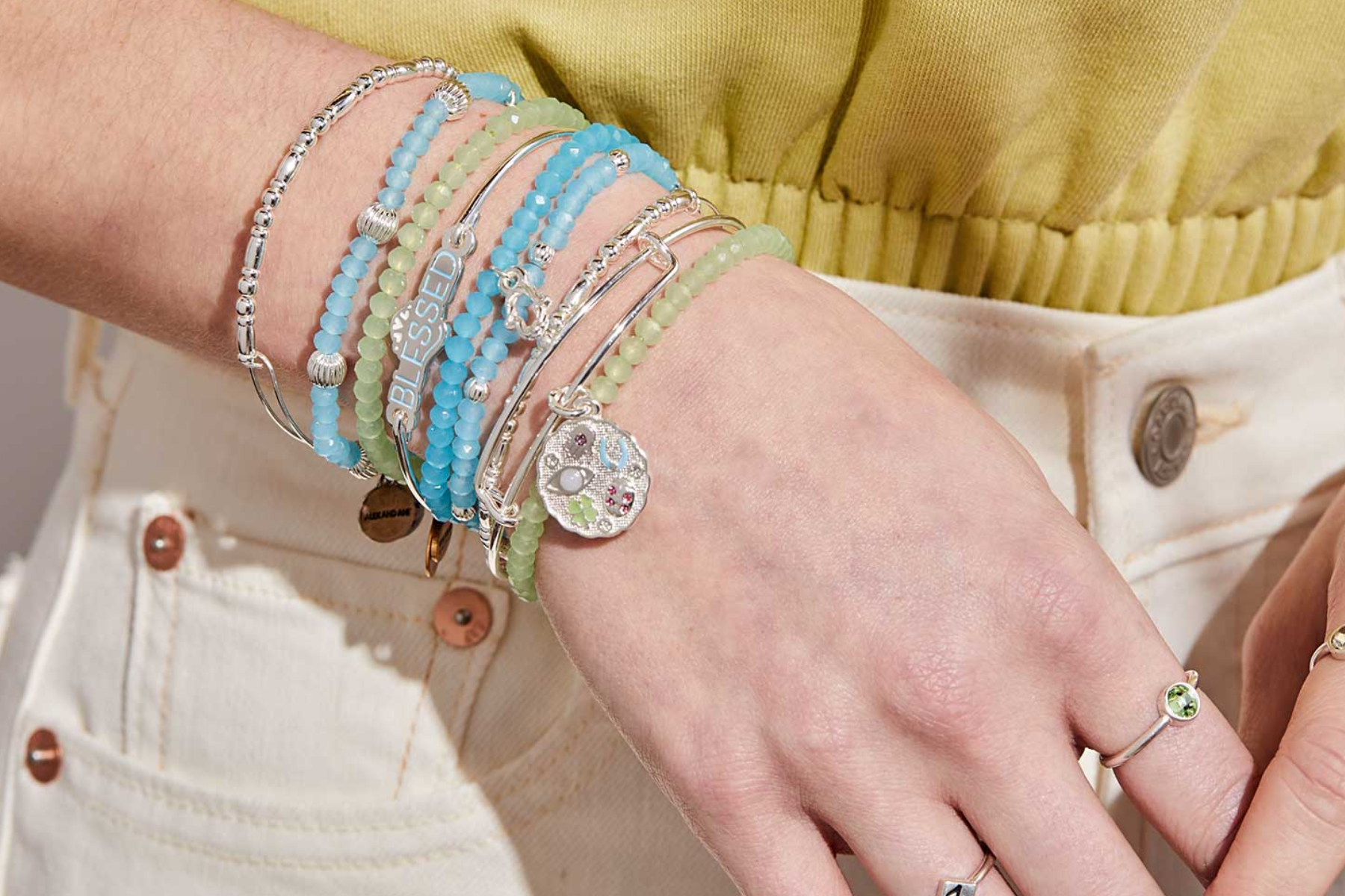 A woman's wrist is adorned with stacked bracelets