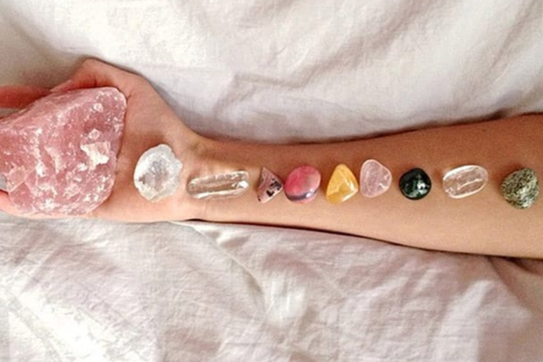 A woman's hand with several gemstones aligned
