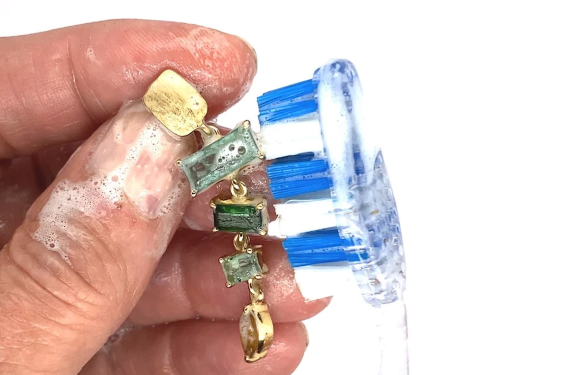 A soft brush is used to clean birthstone jewelry
