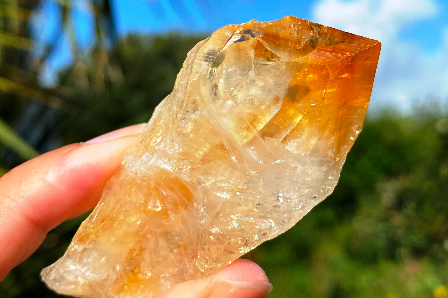 A raw citrine in the palm of a hand