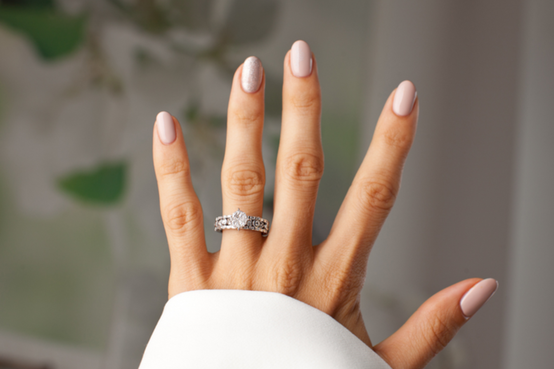 A woman's hand is decked with a conventional wedding ring