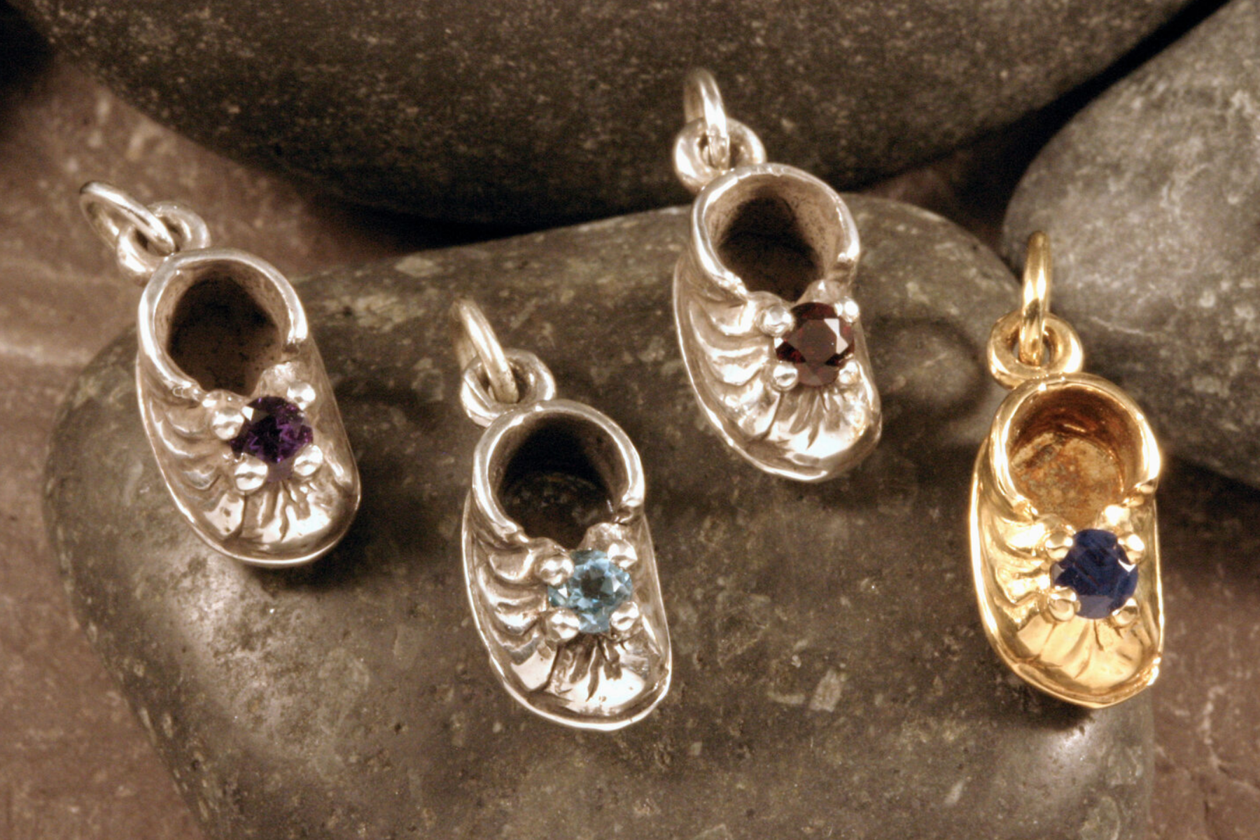 Four tiny shoe charms containing birthstones