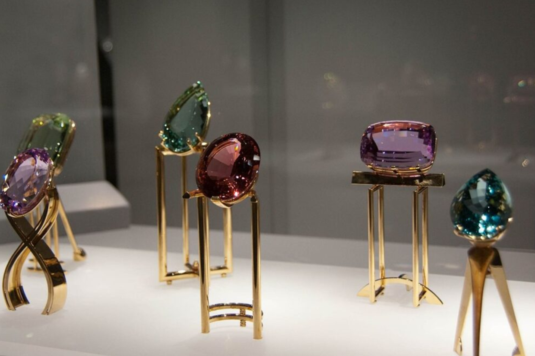 In a glass box, six birthstones are displayed
