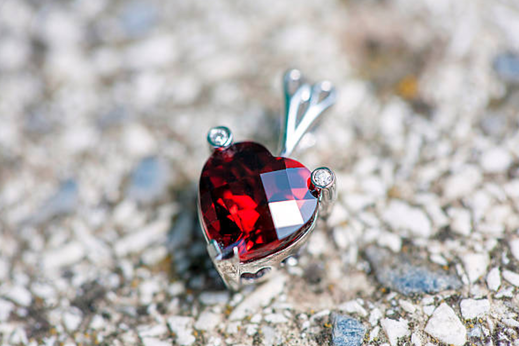 A garnet stone pendant placed in a rocky setting