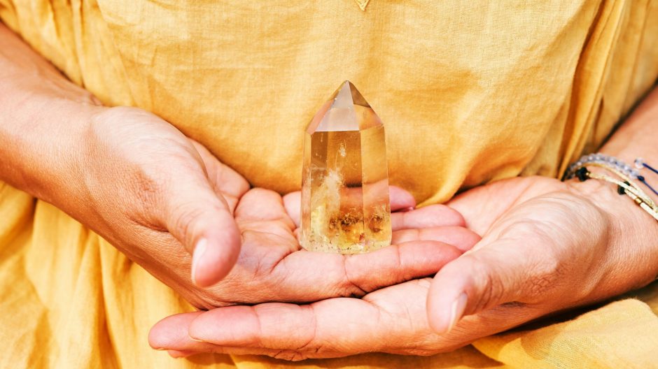 A woman holding a Citrine crystal with her two hands
