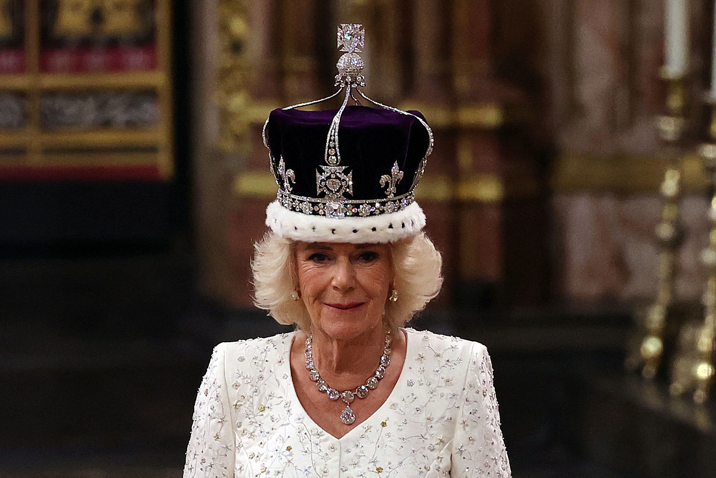 Queen Camilla wearing a white outfit and royal crown